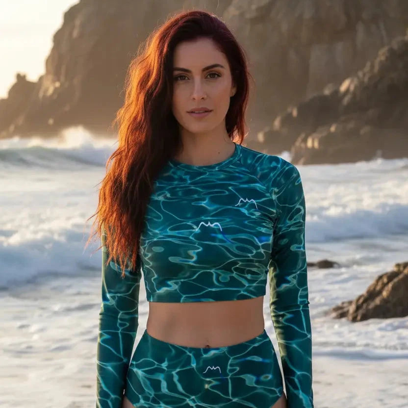 femme portant le bikini de surf uhaina crop top manches longues motif eau vert sur une plage