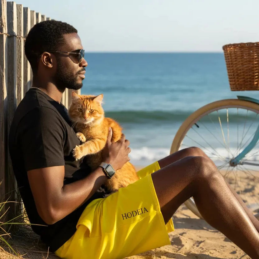 homme portant le maillot de surf indar coloris jaune avec un chat à la plage