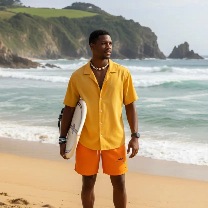 homme portant le maillot de surf indar coloris orange sur une plage