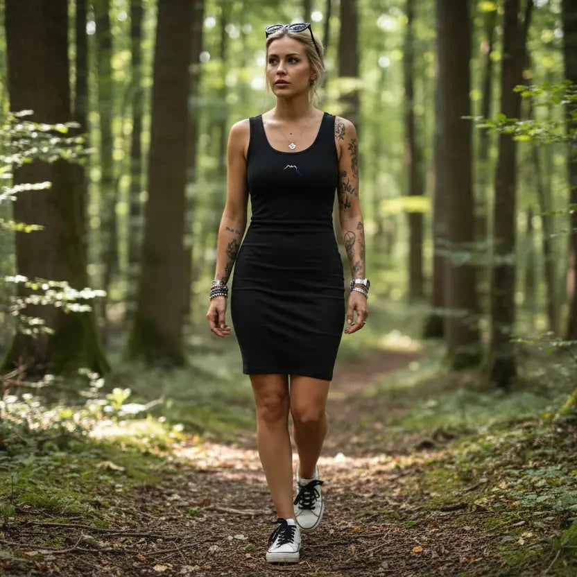 femme portant la robe courte moulante sans manches éco-responsable zumaia coloris noir dans une forêt