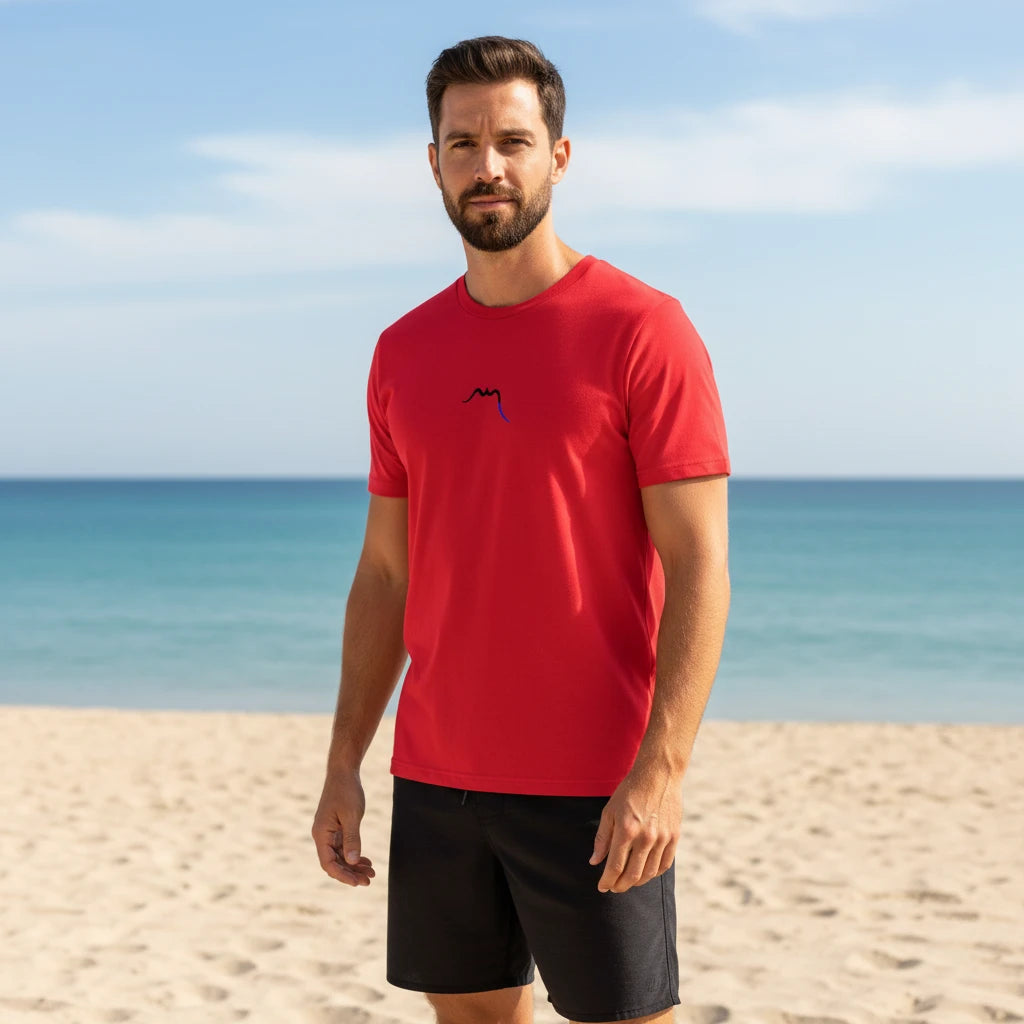 homme portant le t-shirt premium en coton bio zéro coloris rouge à la plage