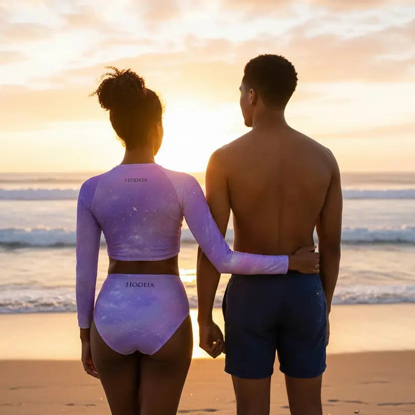 femme portant le bikini de surf uhaina crop top manches longues motif ciel étoilé sur une plage