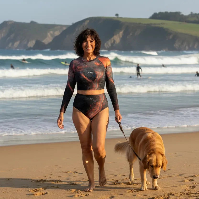 femme portant le bikini de surf uhaina crop top manches longues motif lave sur une plage avec des surfeurs