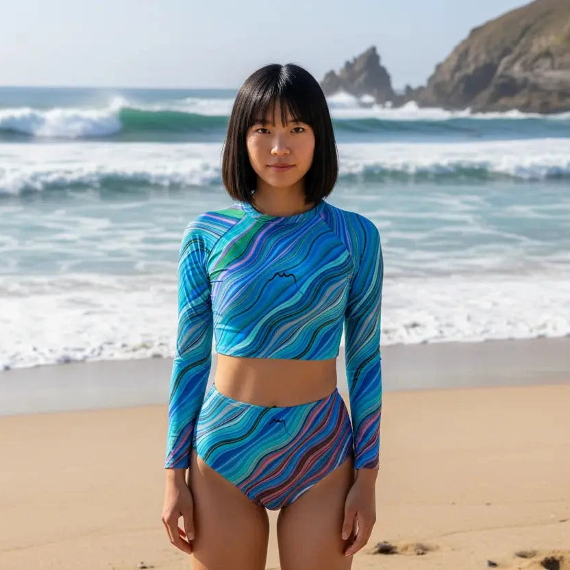 femme portant le bikini de surf uhaina crop top manches longues motif ondulations sur la plage