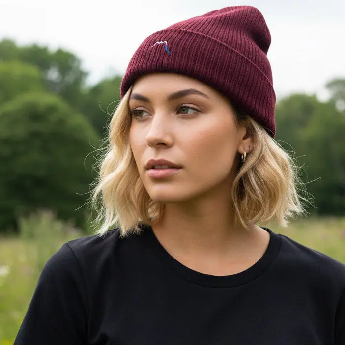 femme portant le bonnet côtelé et brodé en coton bio travis coloris rouge bordeaux en pleine nature