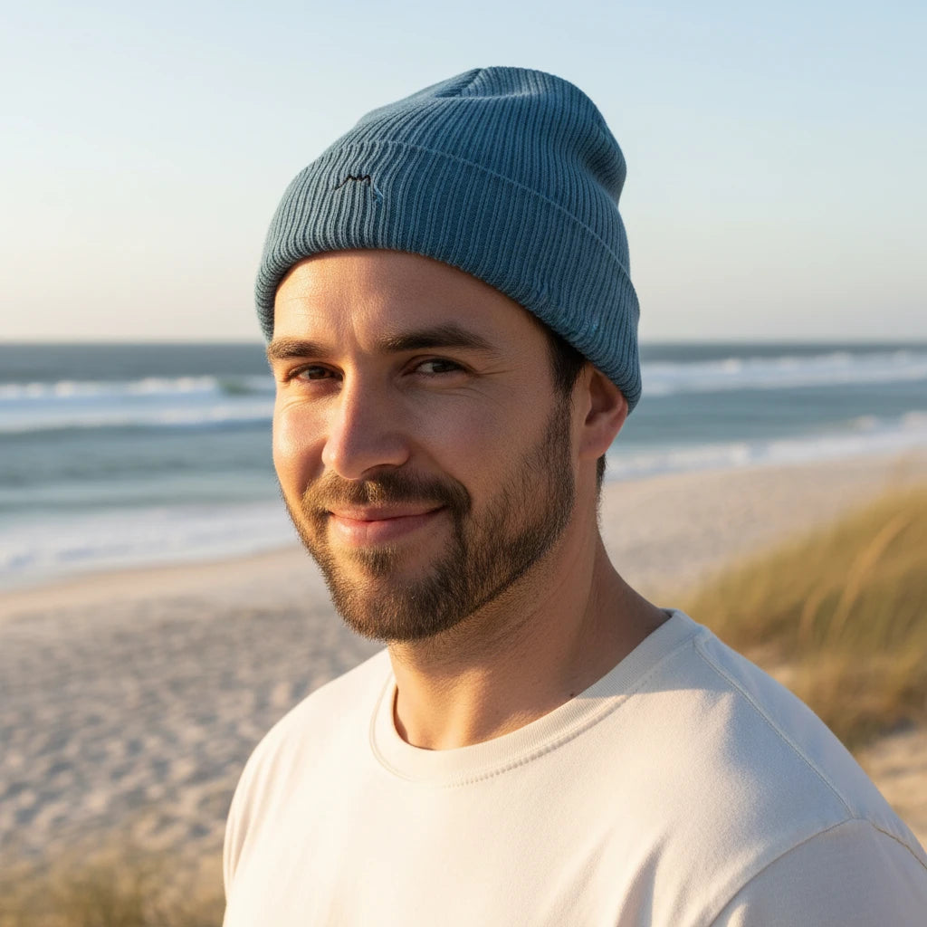 homme portant le bonnet côtelé brodé en coton bio travis coloris bleu glacier à la plage