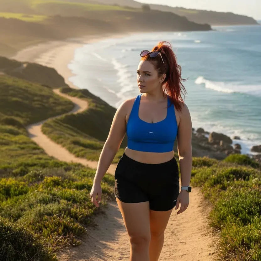 femme portant la brassière de sport éco-responsable carlina coloris bleu roi devant l'océan