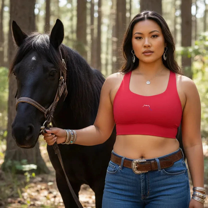 femme portant la brassière de sport éco-responsable carlina colorisrouge foncé avec son cheval en forêt