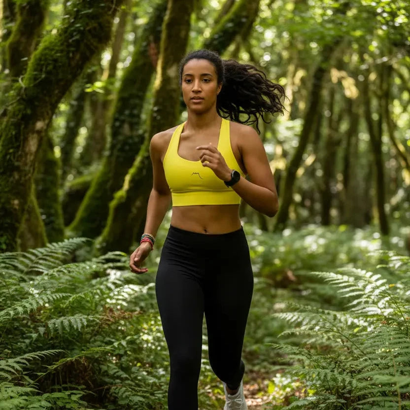 femme portant la brassière de sport éco-responsable carlina coloris jaune en forêt
