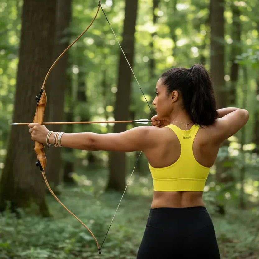 femme portant la brassière de sport éco-responsable carlina coloris jaune qui tire à l'arc