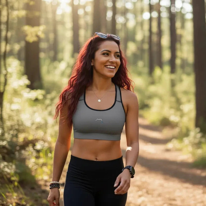 femme portant la brassière de sport éco-responsable rembourée alicia coloris gris et noir en pleine nature