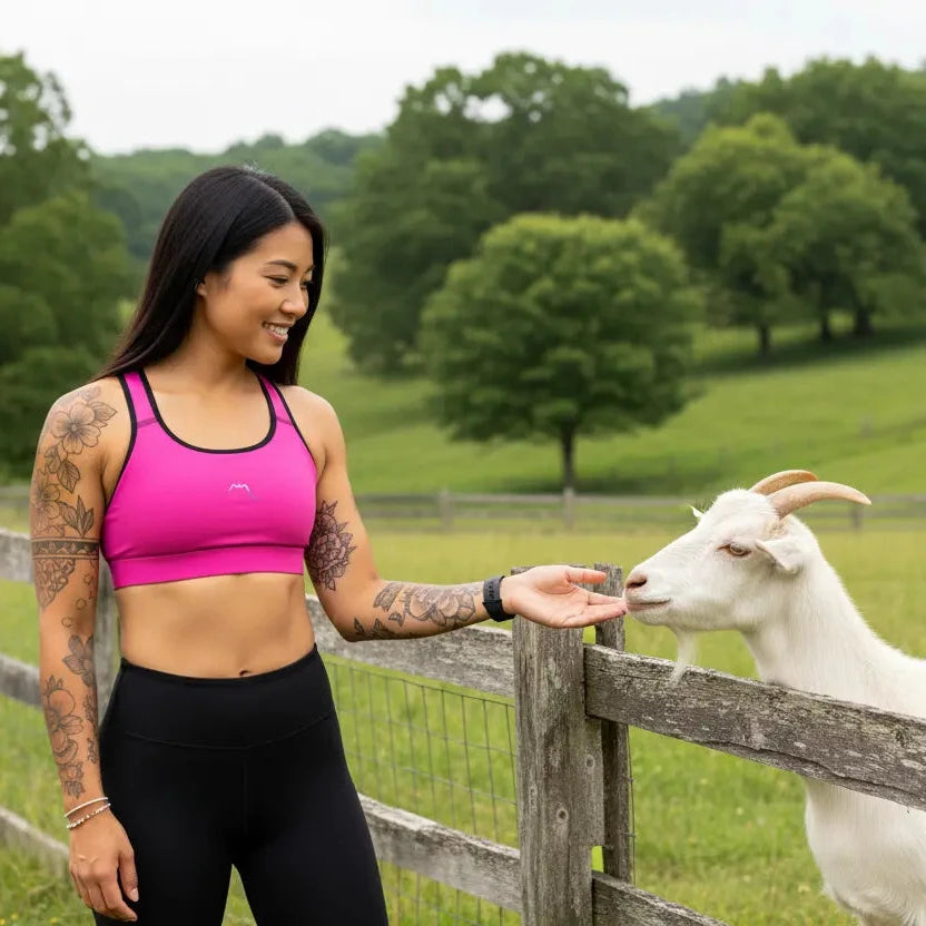 femme portant la brassière de sport éco-responsable rembourée alicia coloris rose fuchsia et noir à la campagne
