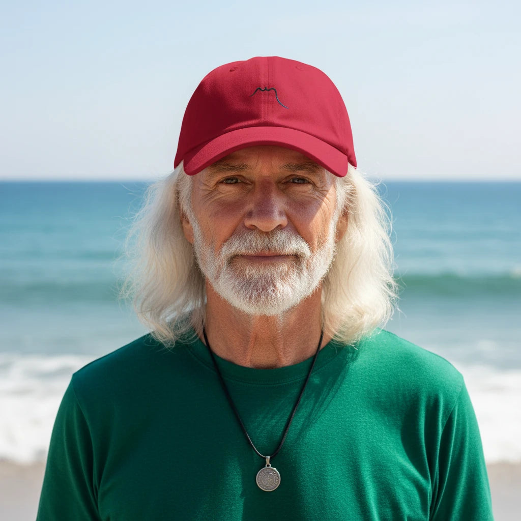 homme portant la casquette de baseball en sergé de coton réglable coloris rouge foncé à la plage