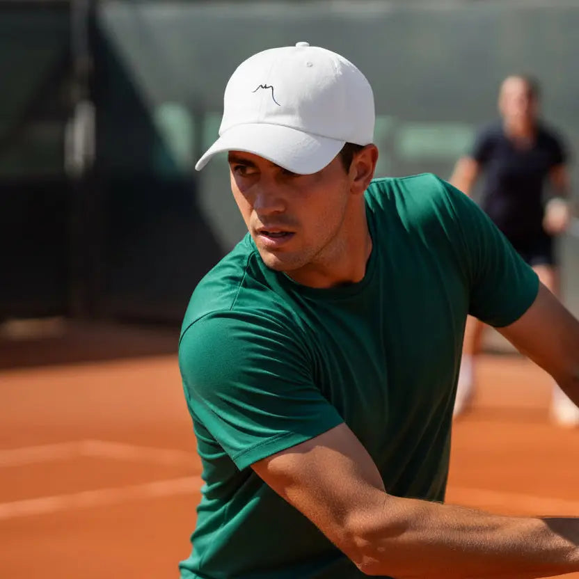 homme portant la casquette de baseball en sergé de coton réglable coloris blanc en jouant au tennis