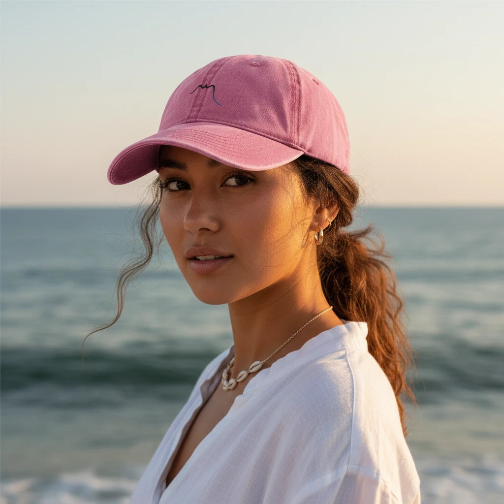 femme portant la casquette vintage en sergé de coton réglable coloris rose sur la plage 
