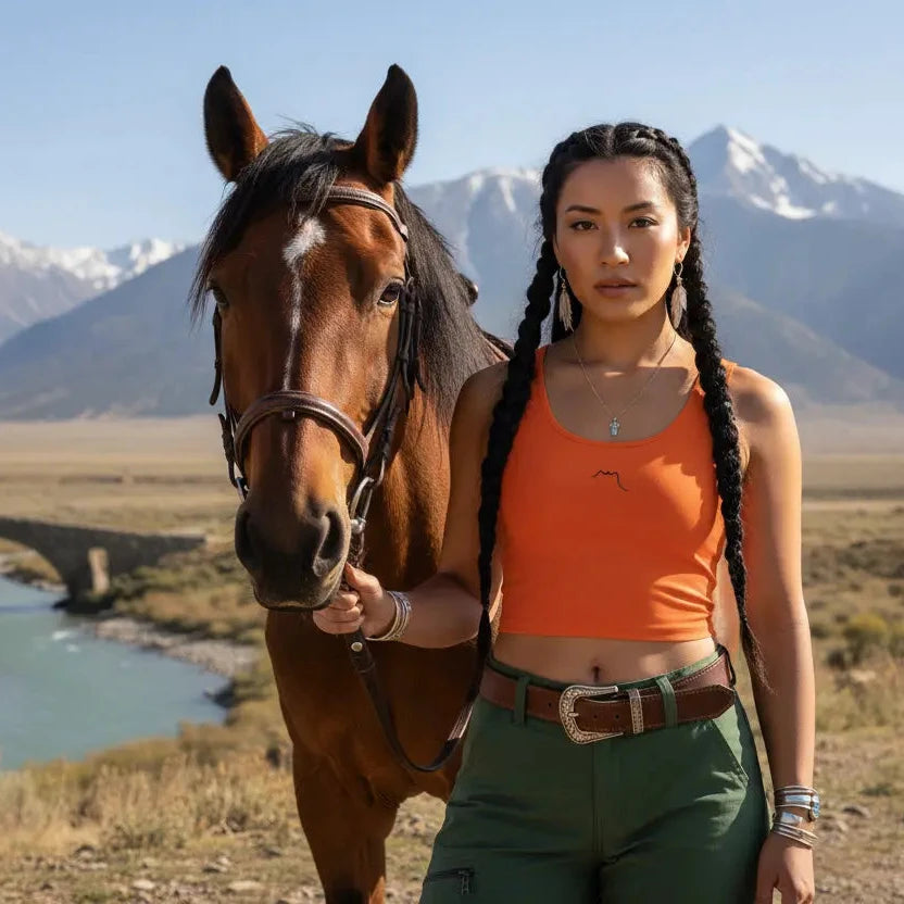 femme portant le crop top yesa coloris orange avec un cheval en pleine nature