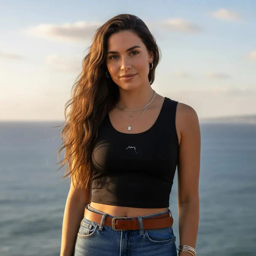 femme portant le crop top yesa coloris noir devant l'océan