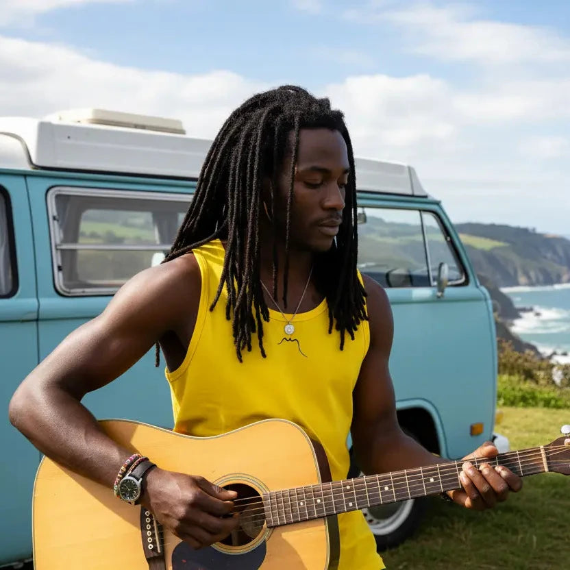 homme portant le débardeur aizkora coloris jaune qui joue de la guitare devant son van