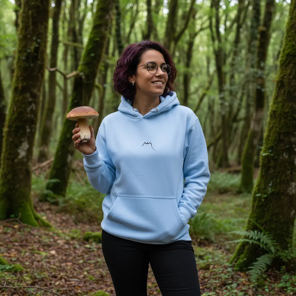 femme portant le hoodie en coton negua coloris bleu clair dans une forêt