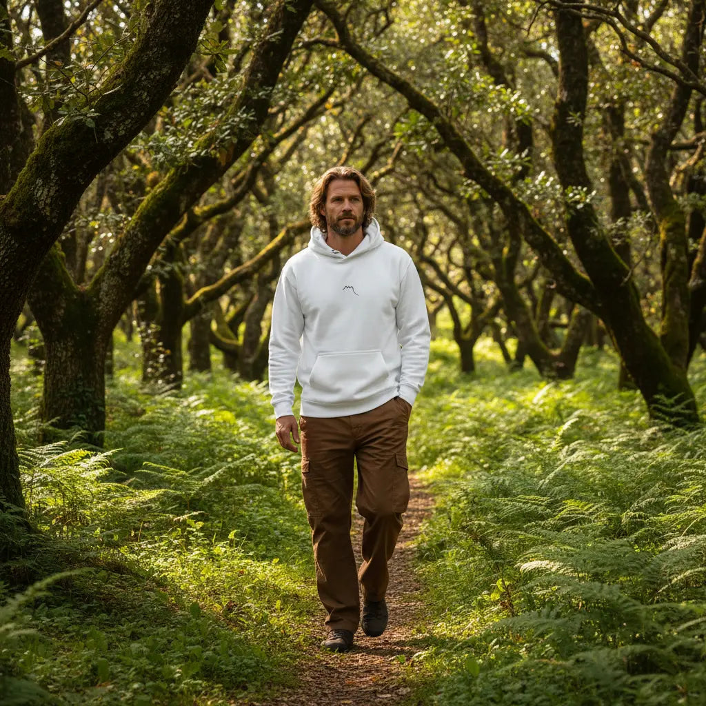 homme portant le hoodie en coton bio negua coloris banc dans une forêt