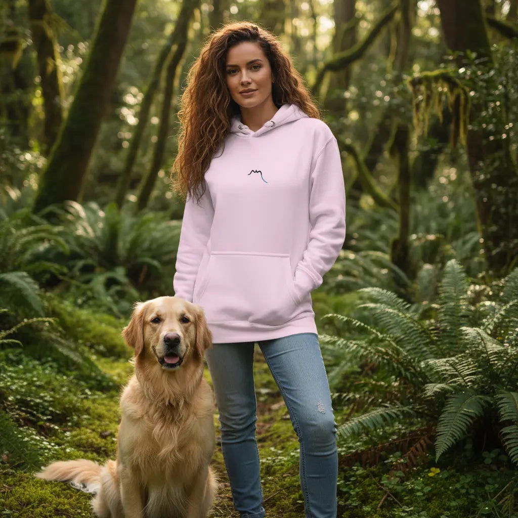 femme portant le hoodie en coton bio negua coloris rose pâle en forêt avec son chien 