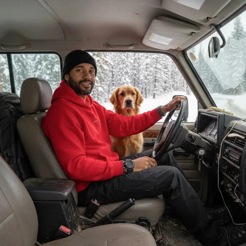 homme portant le hoodie negua coloris rouge logo blanc en voiture avec son chien