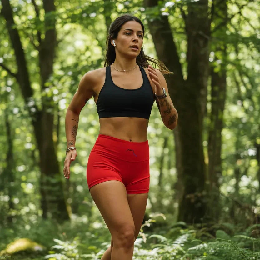femme portant le legging short coloris rouge qui court en forêt