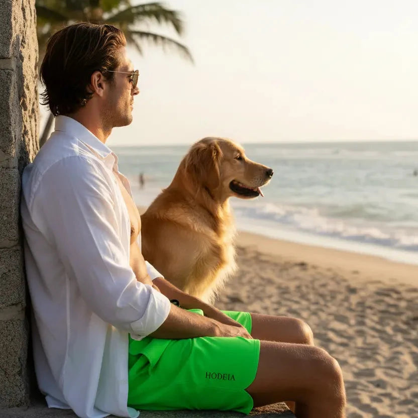 homme portant le maillot de surf indar coloris vert avec son chien sur une plage