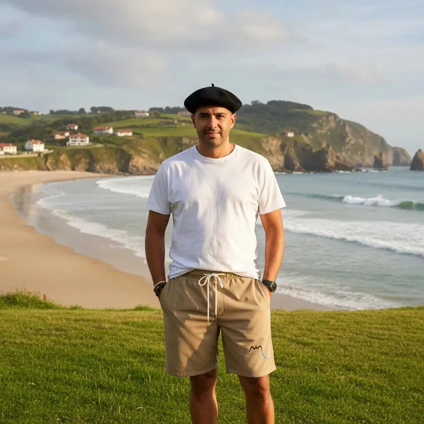 homme portant le maillot de surf indar coloris beige devant une plage du pays basque