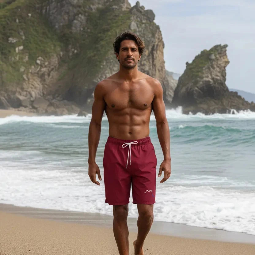 homme portant le maillot de surf indar coloris rouge bordeaux sur une plage sauvage du pays basque