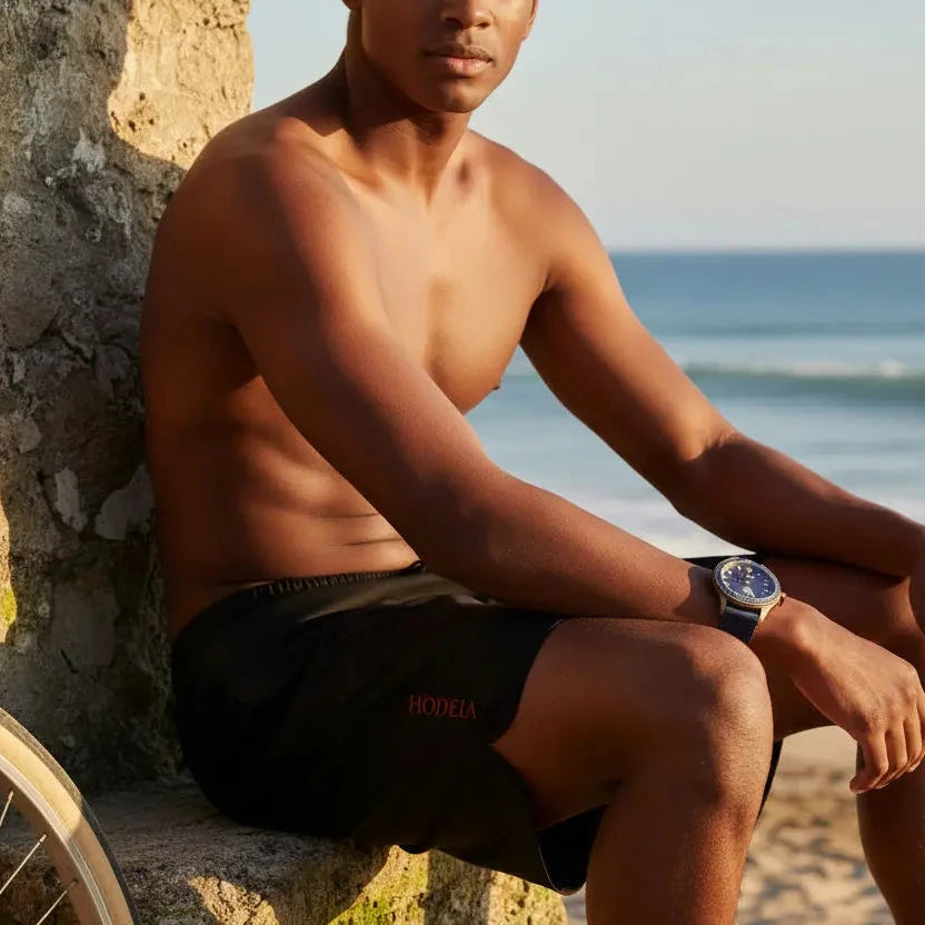 homme portant le maillot de surf indar coloris noir sur une plage