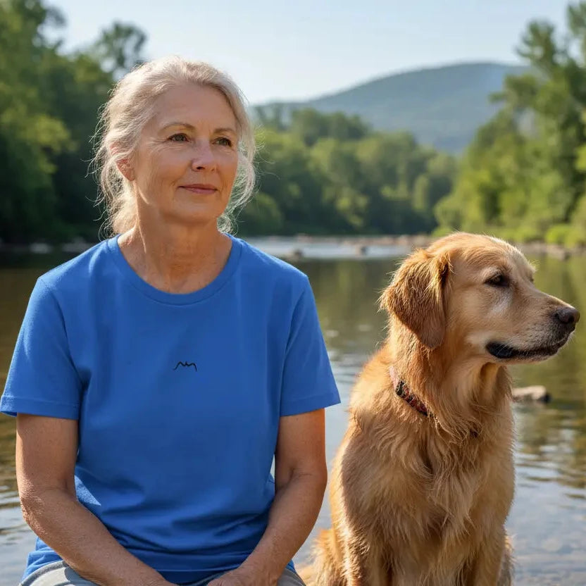 femme portant le t-shirt coton cintré femme insola coloris bleu logo noir devant une rivière avec son chien