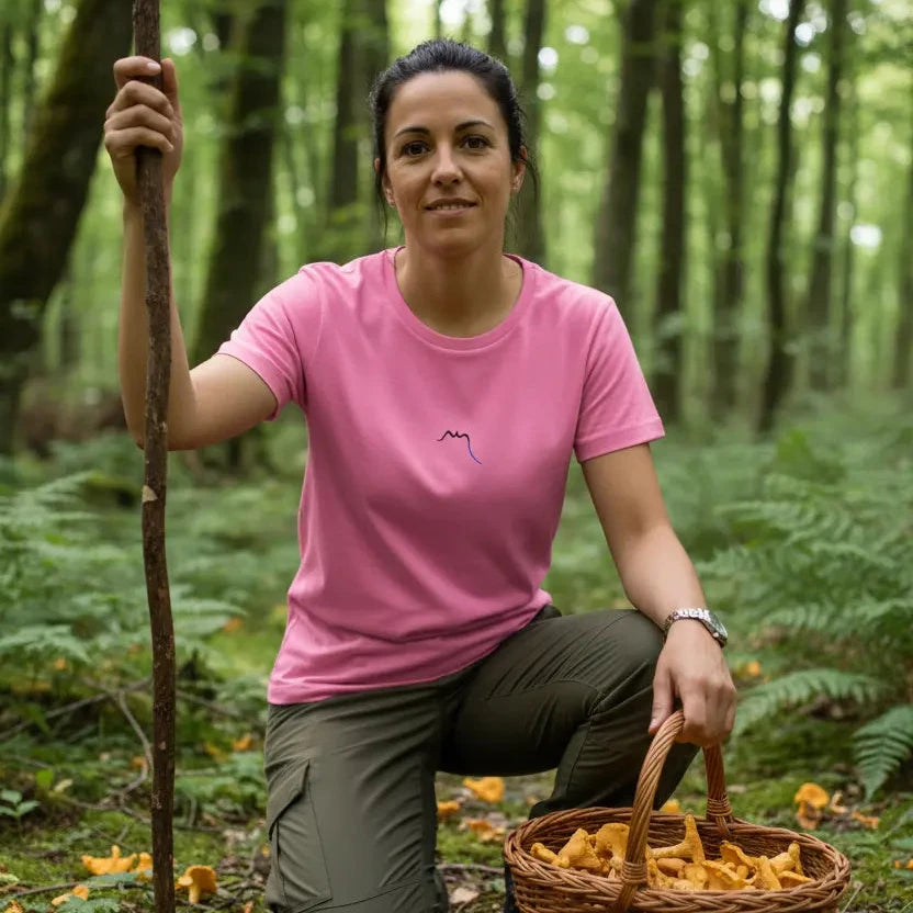 femme portant le t-shirt coton cintré femme insola coloris rose logo noir qui cueille des girolles en forêt