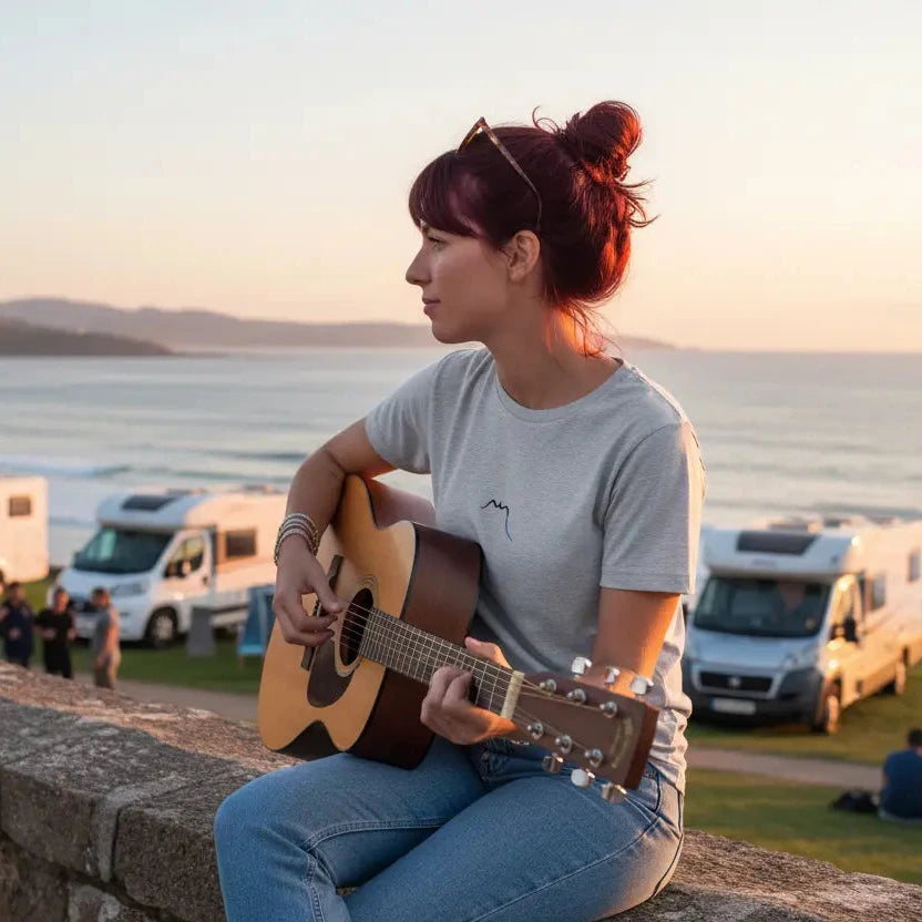 femme portant le t-shirt coton cintré femme insola coloris gris qui joue de la guitare devant des camping-car au bord de l'océan