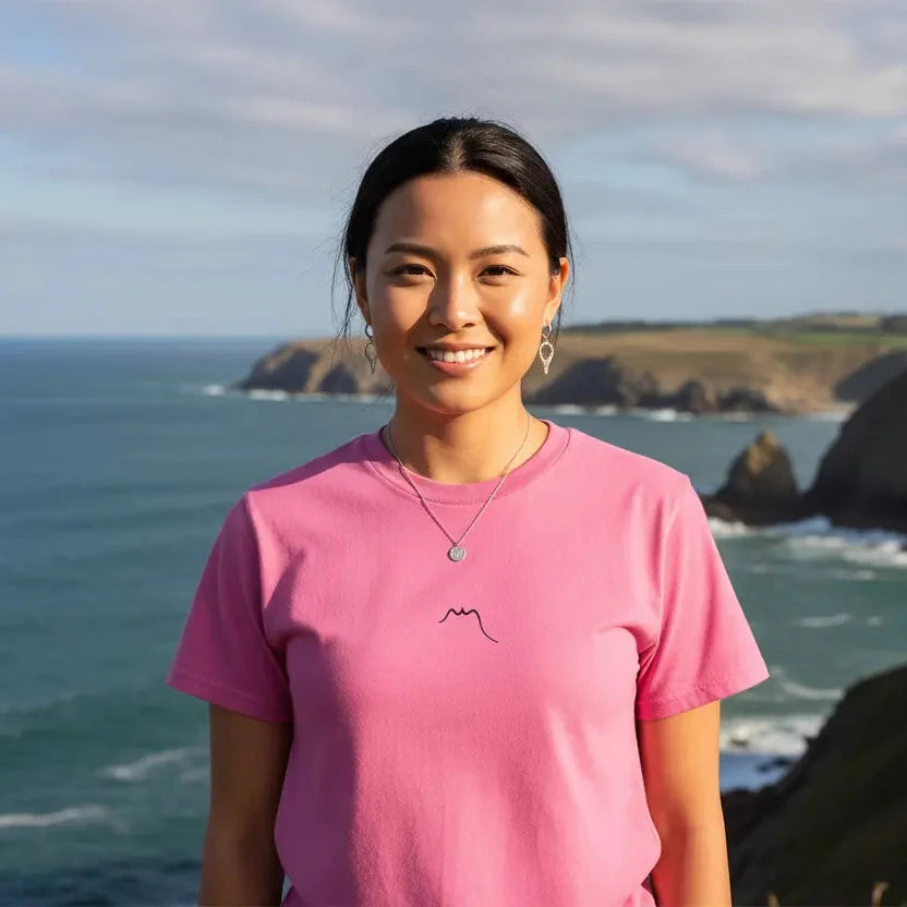 femme portant le t-shirt coton femme homme l'ermite coloris rose devant l'océan