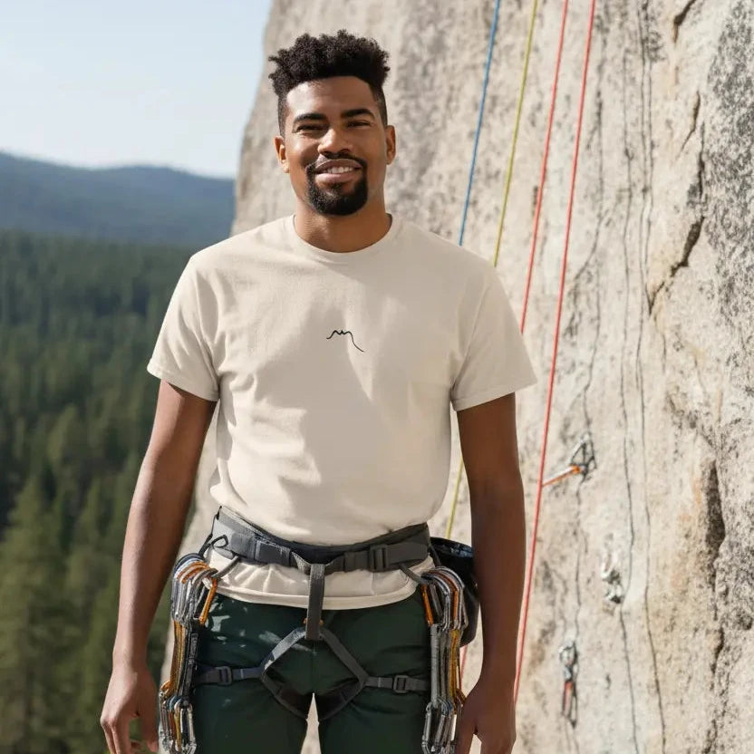 homme portant le t-shirt coton femme homme l'ermite coloris beige pierre devant un mur naturel d'escalade