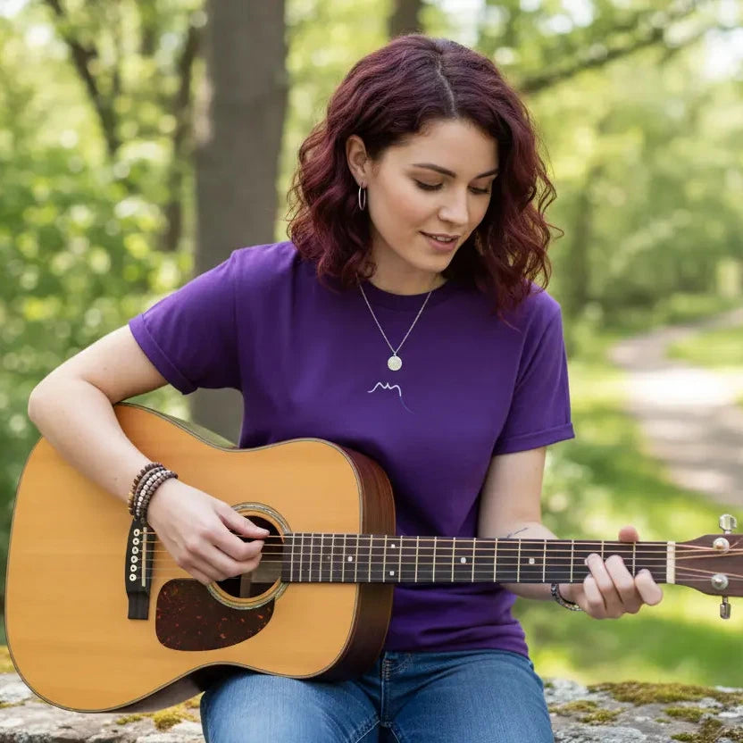 femme portant le t-shirt coton femme homme l'ermite coloris violet jouant de la guitare en pleine nature