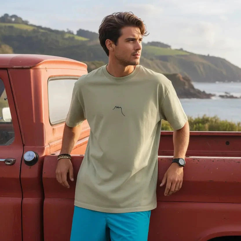 homme portant le t-shirt coton femme homme oversize grande taille le cool coloris kaki clair devant son vieux pickup sur la côte