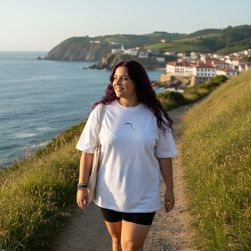 femme portant le t-shirt grande taille en coton bio brodé le pottolo coloris blanc sur une pomenade du pays basque