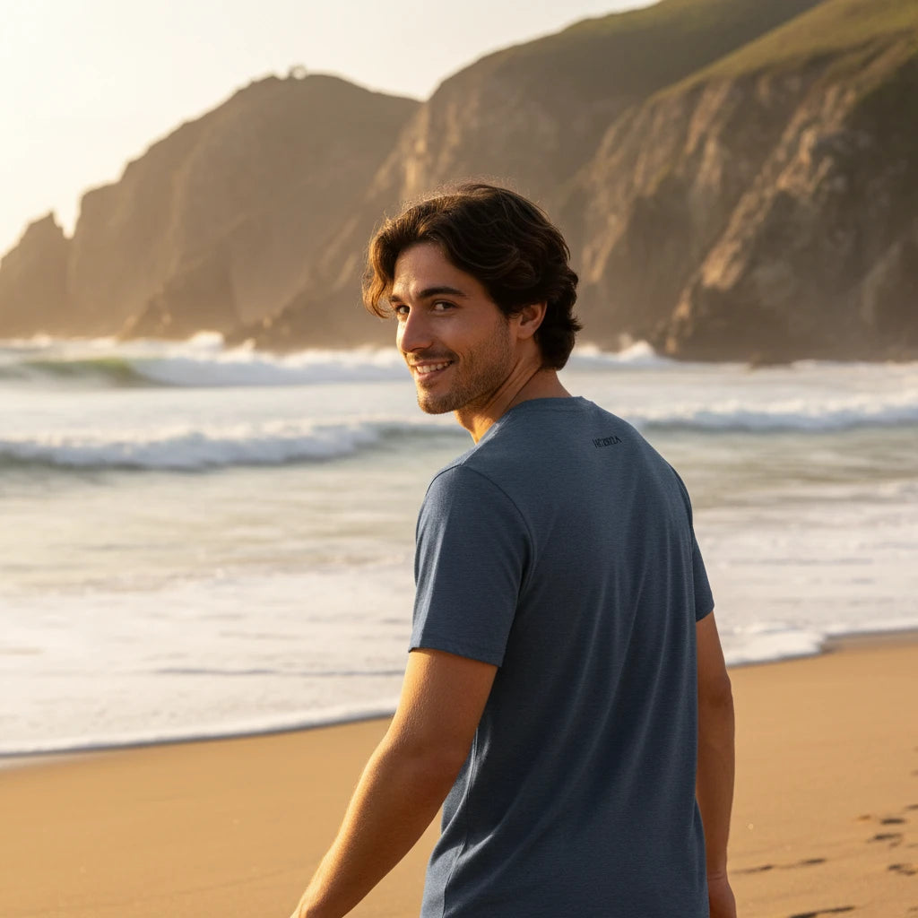 homme portant le t-shirt premium en coton bio zéro coloris gris bleu à la plage