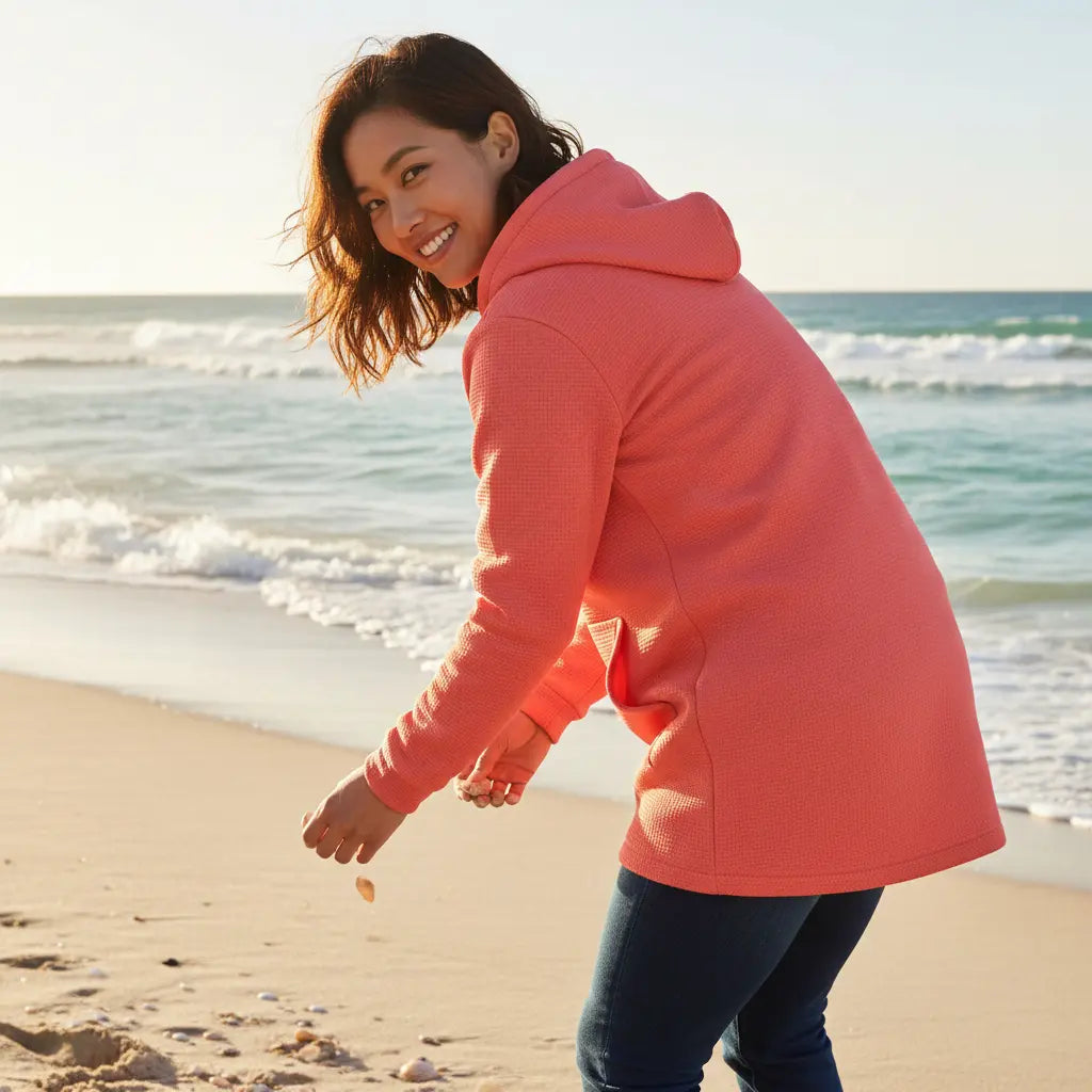 femme portant la veste polaire longue bolivia de dos coloris rose foncé à la plage