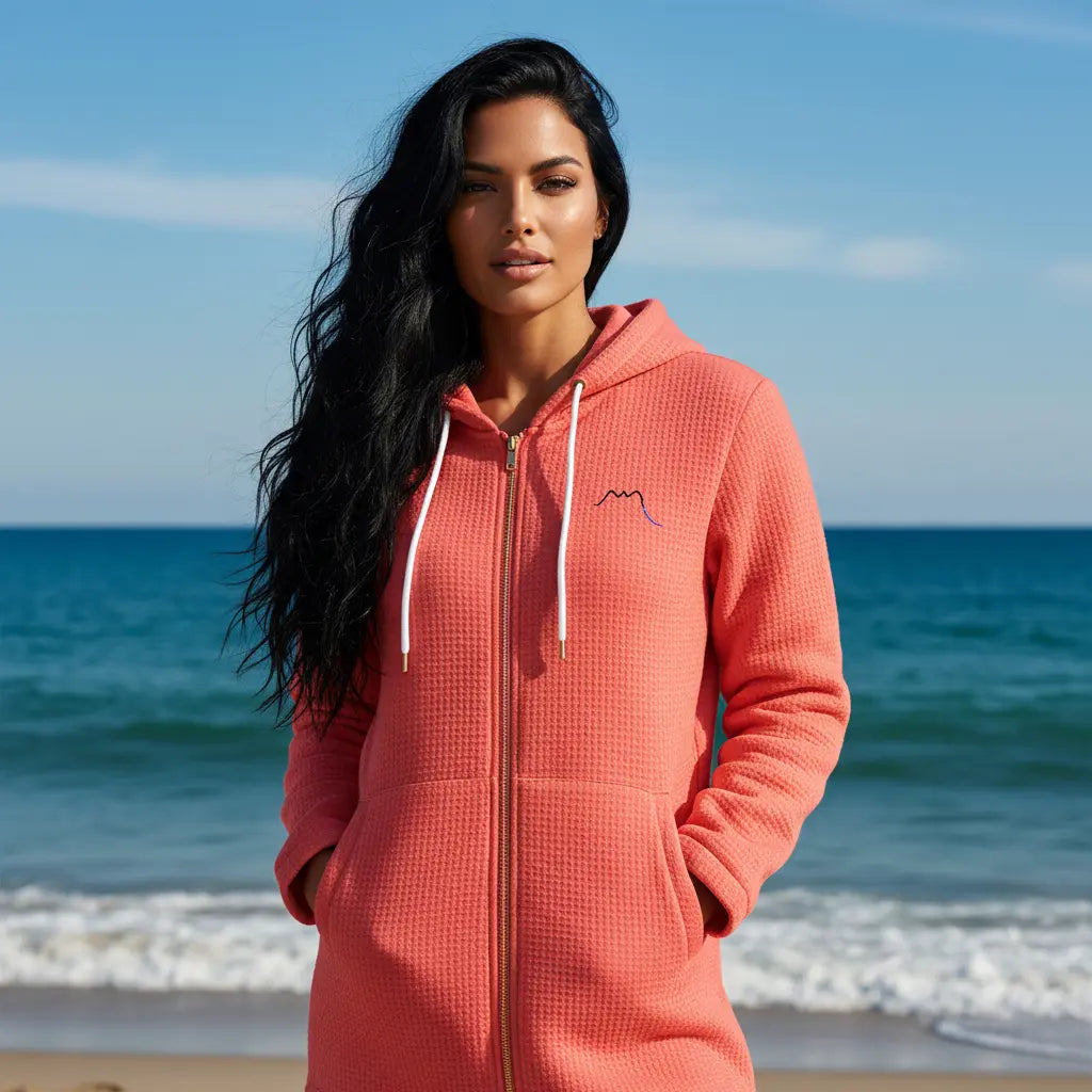 femme portant la veste polaire longue bolivia de face coloris rose foncé à la plage