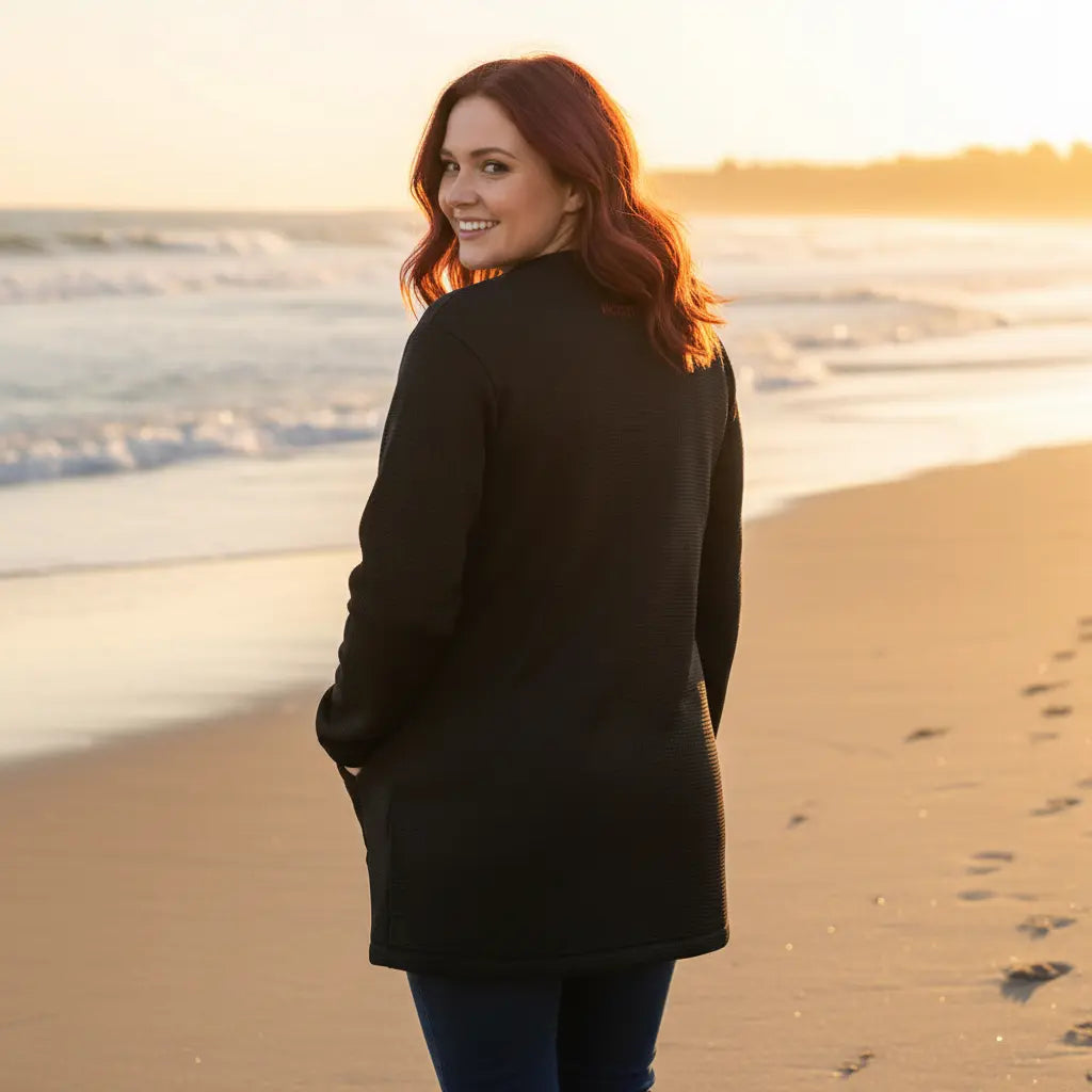 femme portant la veste polaire longue bolivia de dos coloris noir à la plage