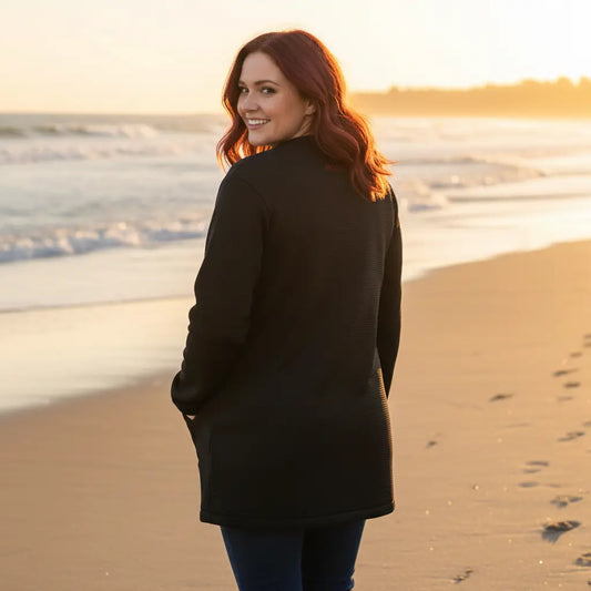 femme portant la veste polaire longue bolivia de dos coloris noir à la plage