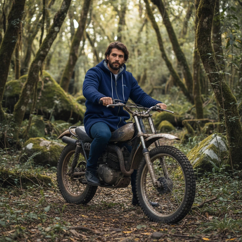 homme portant la veste polaire longue chili coloris bleu marine sur une moto trial en forêt 